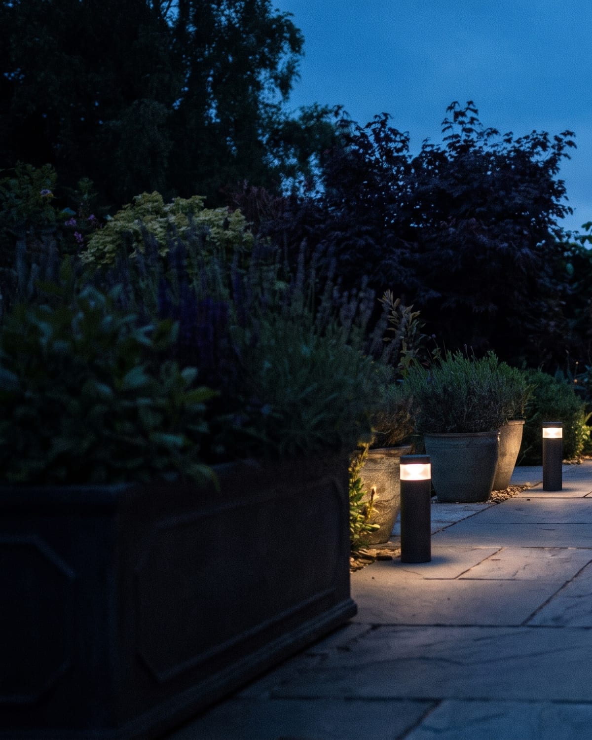 A garden terrace at dusk lit by Nichee path and wall lights